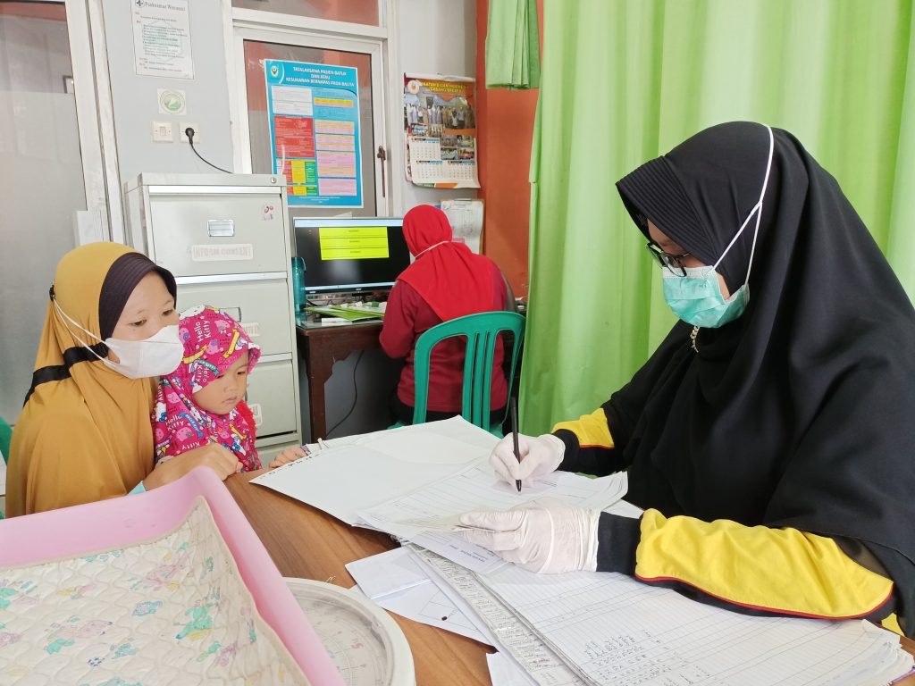 Doctor at a Puskesmas in Brebes examines a mother and child during health checkup