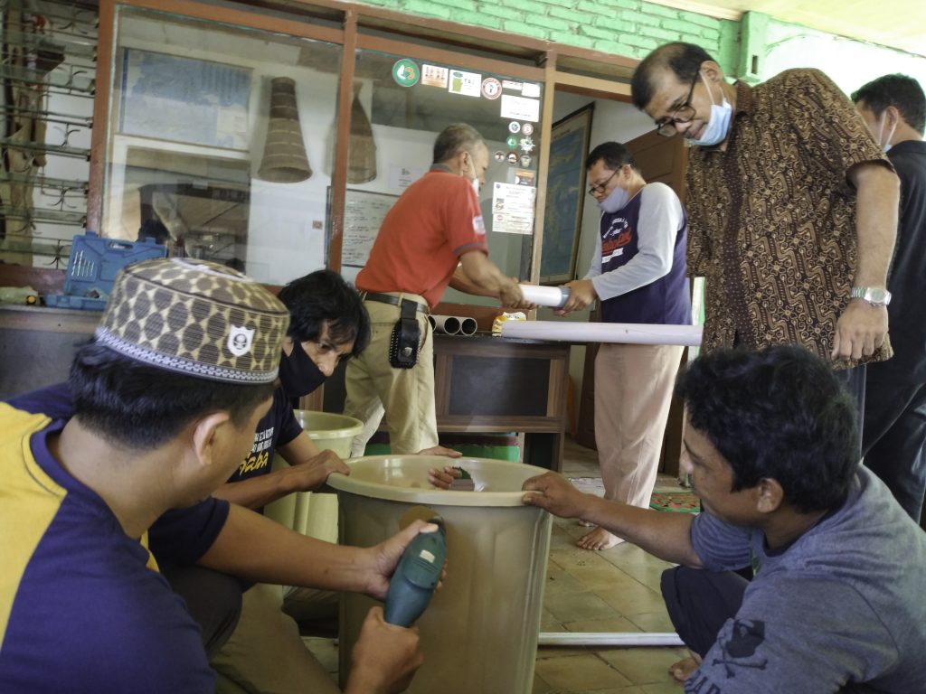 Members of the local multi-stakeholder forum, Mappacing, learn to construct treatment containers
that helps recycle organic waste into liquid fertilizer, compost, and protein for animal feed.